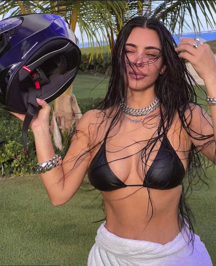 Kim Kardashian poses in seamless blackack SKIMS bra on beach